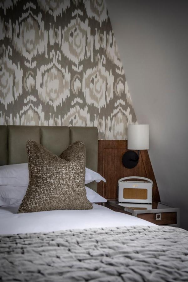 The Marylebone Hotel Londýn Exteriér fotografie A bedroom with a bed, a nightstand, a lamp, and a pillow